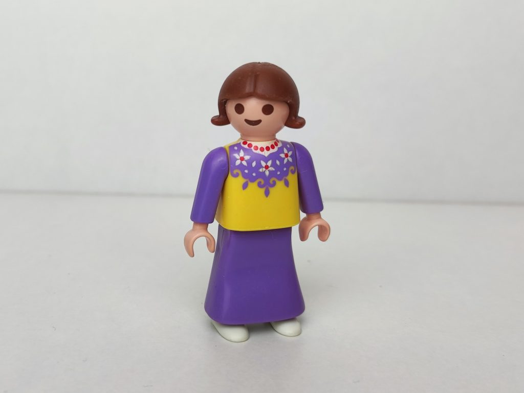 Niña aldeana castaña con vestido lila y amarillo