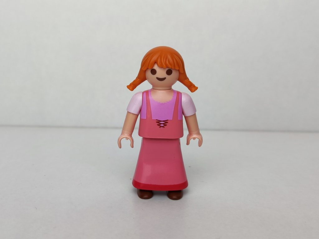 Niña aldeana pelirroja con vestido rosa