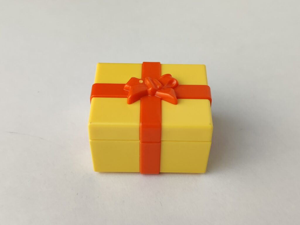 Caja regalo de color amarillo con lazo de color naranja