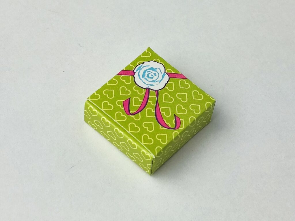 Cajita en miniatura de regalo verde con lazo rosa