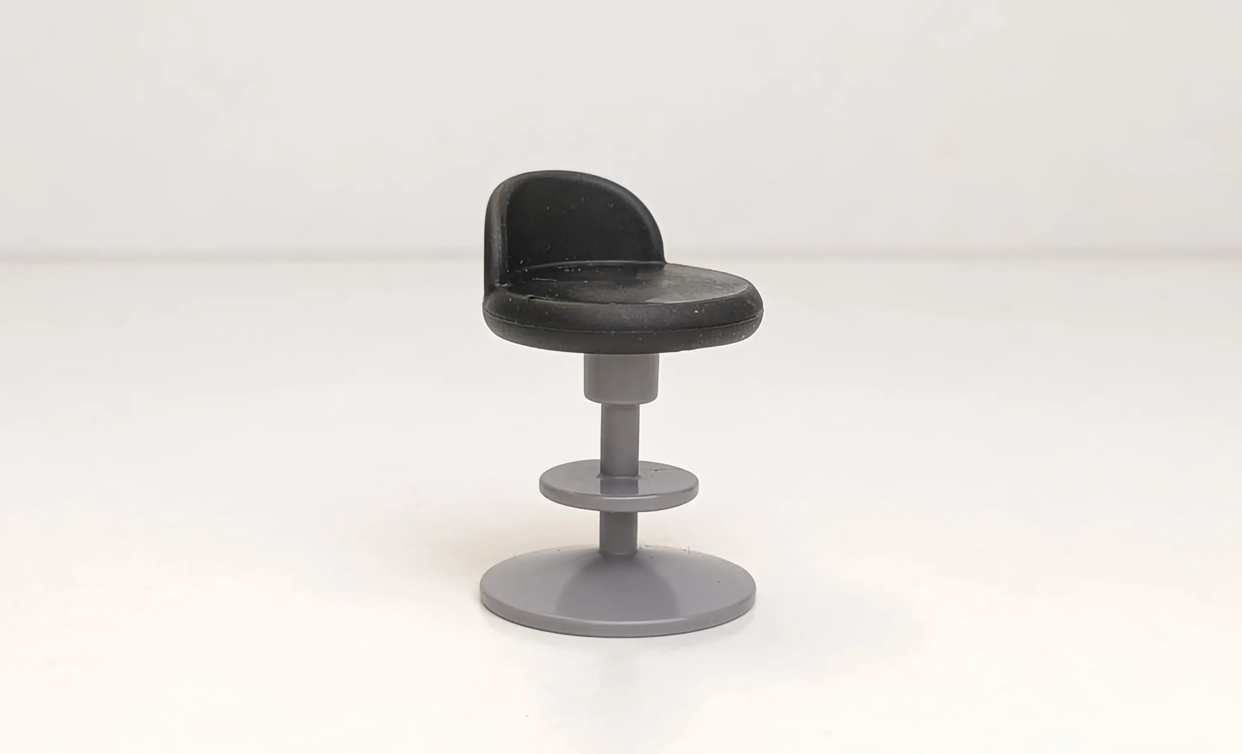 Taburete gris con cojín negro