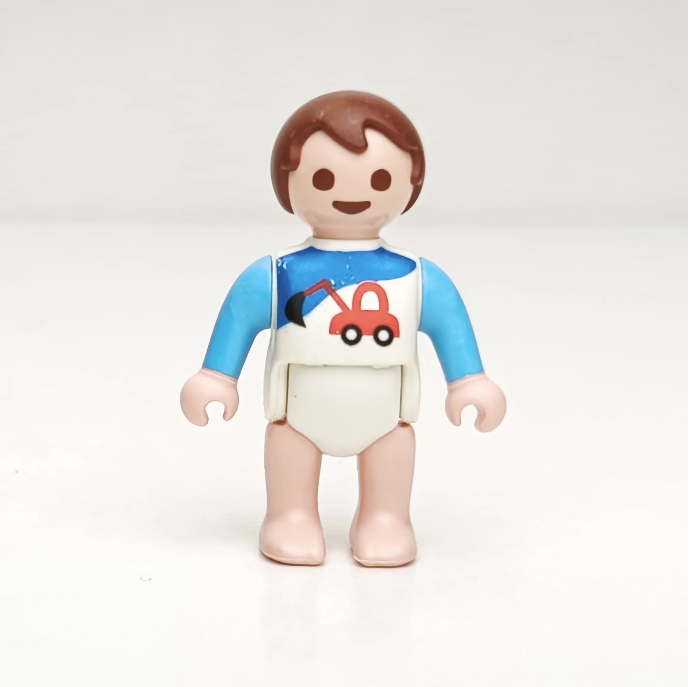 Bebé castaño con camiseta de grúa