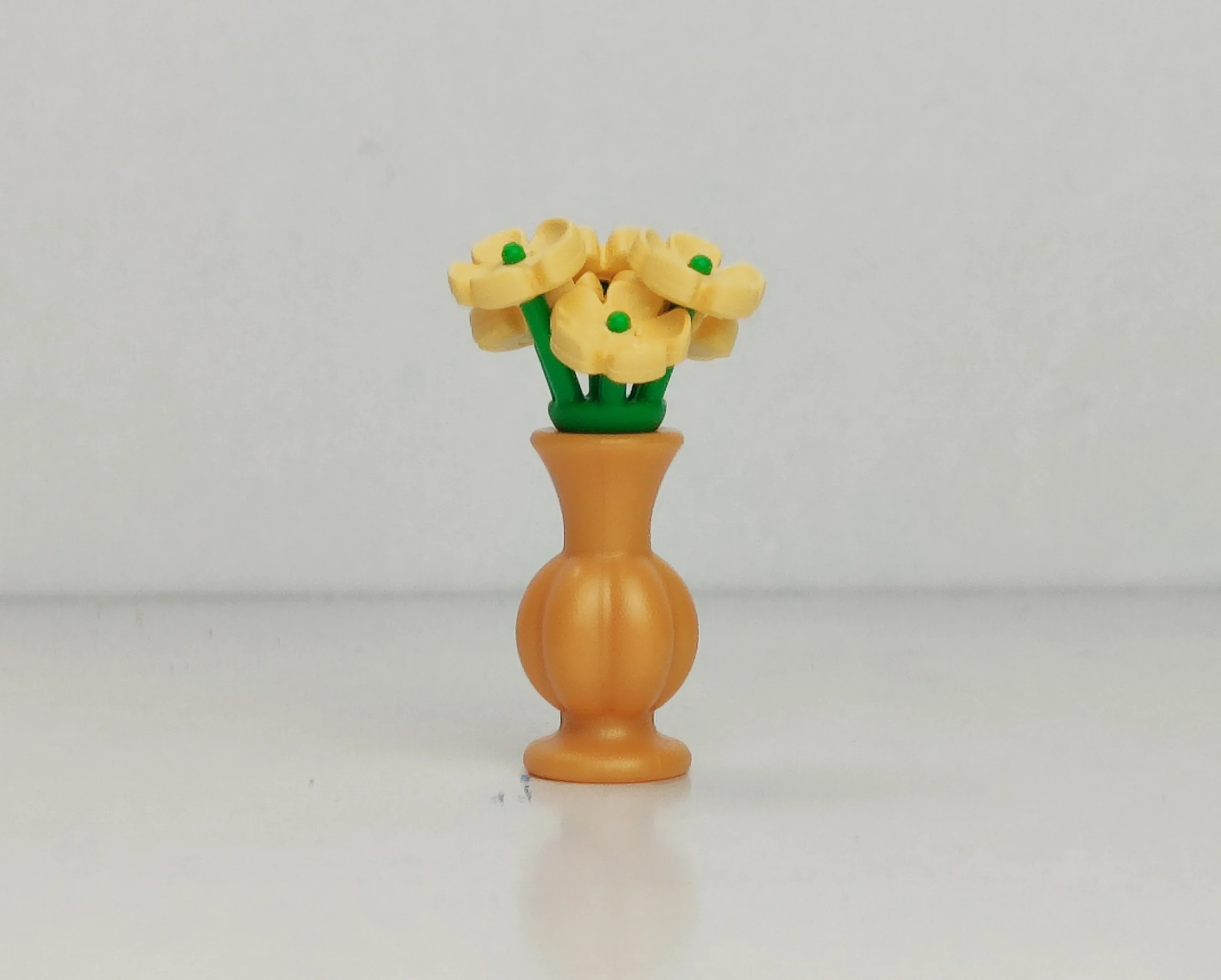 Jarrón dorado con flores amarillas