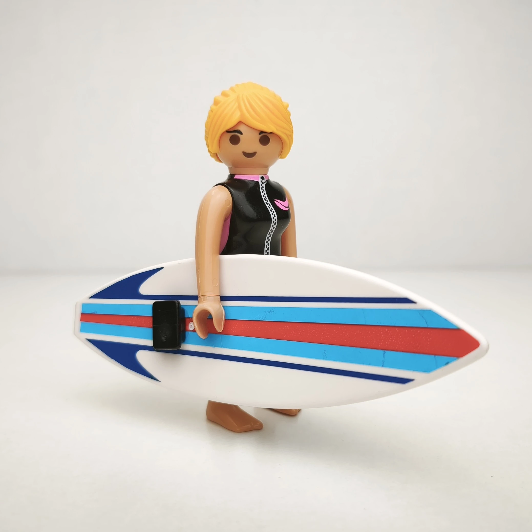 Chica surfista con tabla naranja y azul